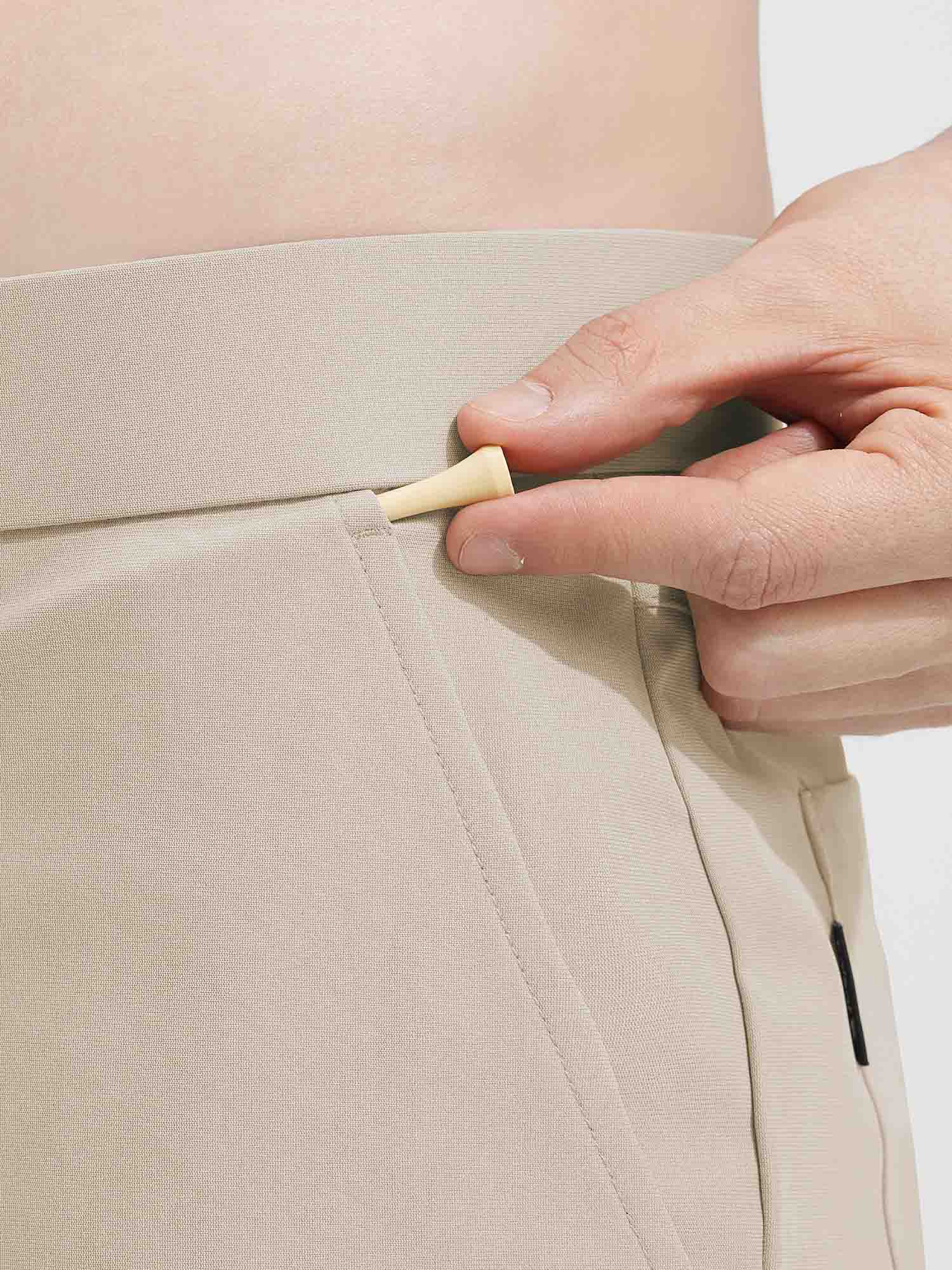 Baleaf light beige golf shorts with elastic waistband and textured fabric, hand holding golf tee. #color_Khaki
