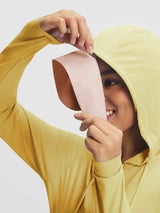Woman adjusts yellow UPF 50+ lightweight sun jacket's removable brim for outdoor leisure. #color_Yellow