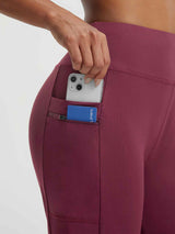Baleaf maroon high-rise running shorts with zippered pocket holding a smartphone and card. #color_Dark Red