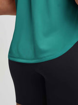 Teal UPF50+ workout tank top with curved hem detail, worn over black athletic bottoms. #color_Teal Green