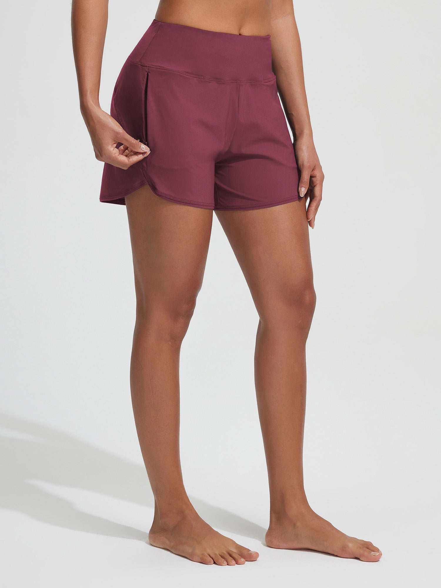 Baleaf women's maroon UPF 50+ board shorts with open zipper pocket detail.