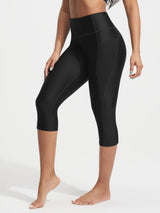 Model in black UPF50+ 18-inch high rise swim capris featuring side pockets and contour stitching. #color_Black