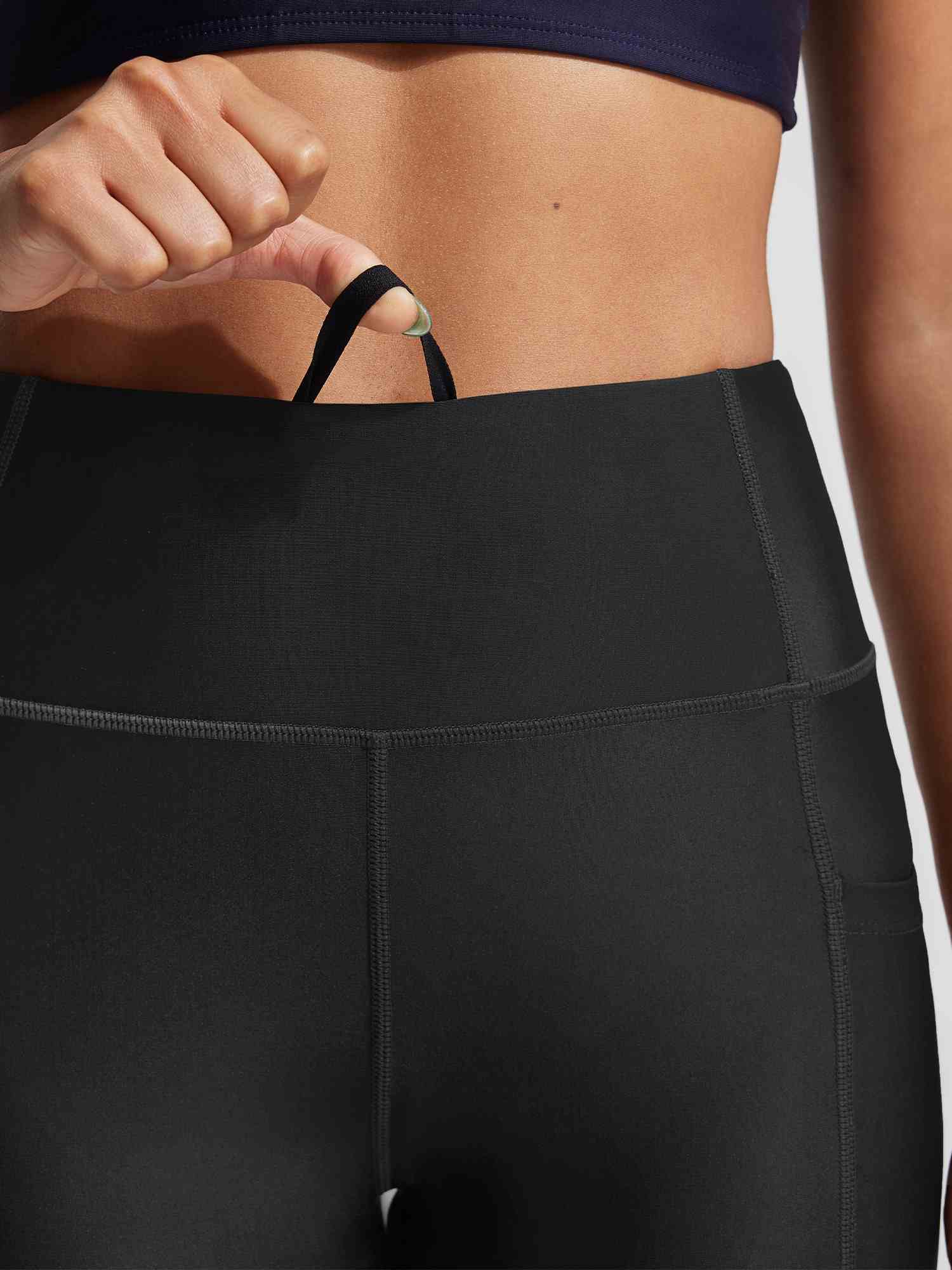 Black UPF50+ high rise swim capris showing drawstring detail and side pocket. #color_Black