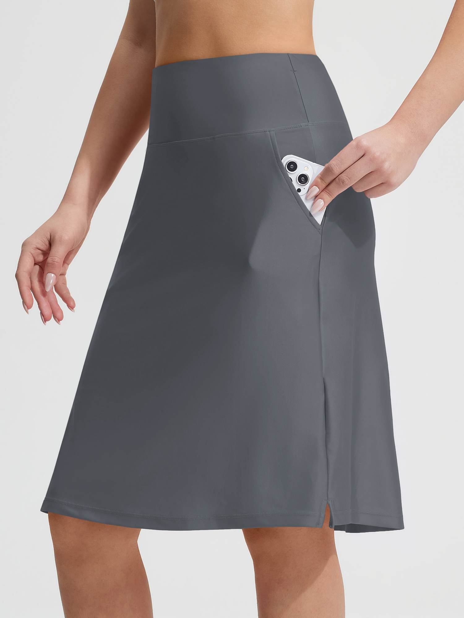 Grey Baleaf UPF 50+ swim skirt featuring slant side pockets, a phone is shown being placed inside one. #color_Dark Gray