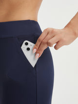 Baleaf navy capri pants with hand placing smartphone in deep side pocket. #color_Navy