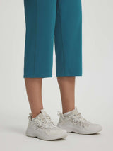 Baleaf women's 18-inch teal straight leg capri pants and white chunky sneakers. #color_Deep Blue