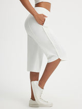 White Baleaf 17-inch high-rise capri pants with side pockets and split hem. #color_White