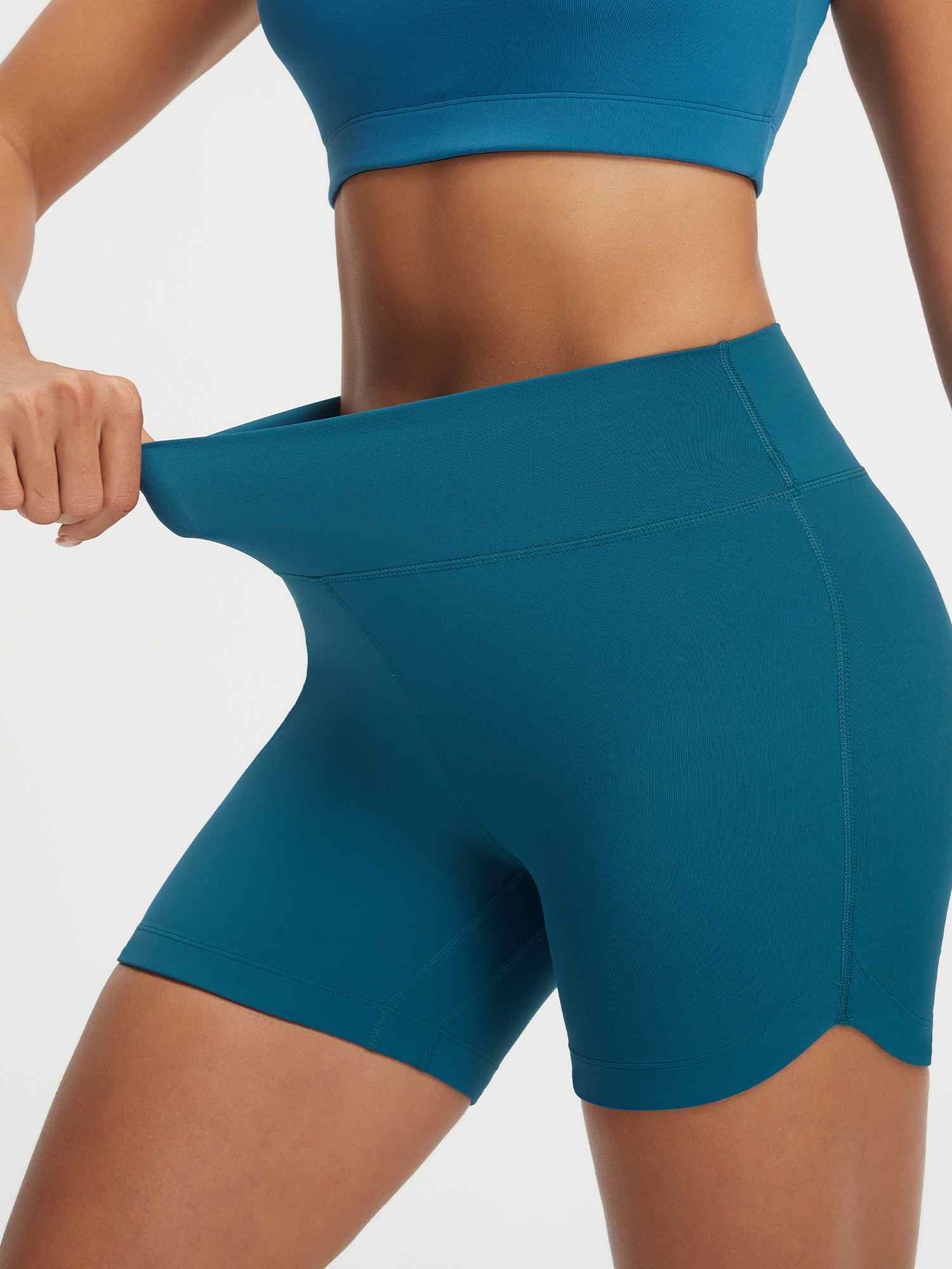 Baleaf teal 5" high-rise biker shorts with stretchy fabric and curved split hem. #color_Deep Blue