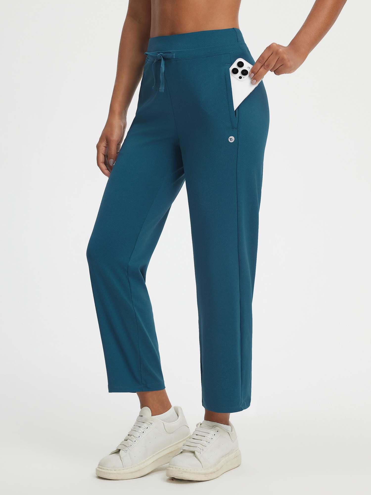 Baleaf high-rise 25" teal pants featuring dual zipper pockets, one holding a phone. #color_Deep Blue