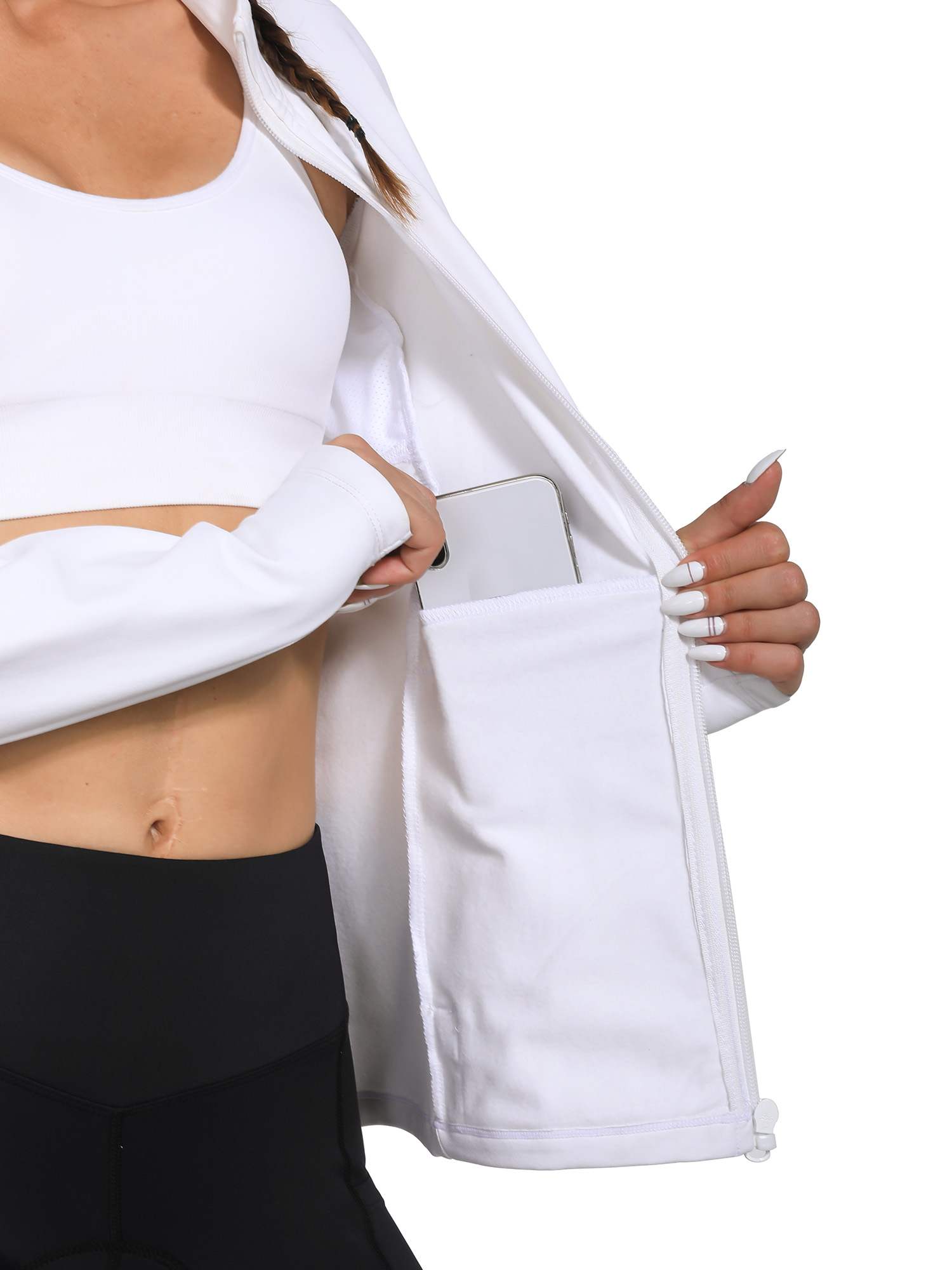 Woman placing smartphone into large inner pocket of white fleece cycling jacket. #color_White