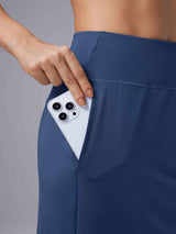 Blue Laureate UPF50+ knee-length skort: hand placing smartphone in side pocket. #color_ Peacoat