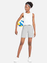 Woman in light gray Laureate 3-Pocket Athletic Shorts and white tank top holding a volleyball. #color_Light Gray