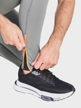 Men's grey fleece-lined running tights with orange zippered cuffs. #color_Gray