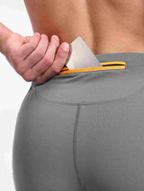 Men's grey running tights with zippered back pocket featuring bright orange & yellow trim. #color_Gray