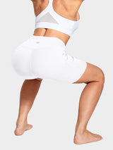 Women's white 6" high-waisted biker shorts with side pockets, shown in active pose. #color_White