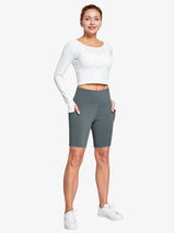 Women's grey high-waisted biker shorts featuring deep pockets, shown on a model with a white long-sleeve top.