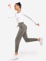 Grey petite tapered joggers on woman in athletic running pose #color_Gray