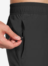 Men's elastic-waist running pants in dark grey, showing zippered side pocket detail. #color_Black