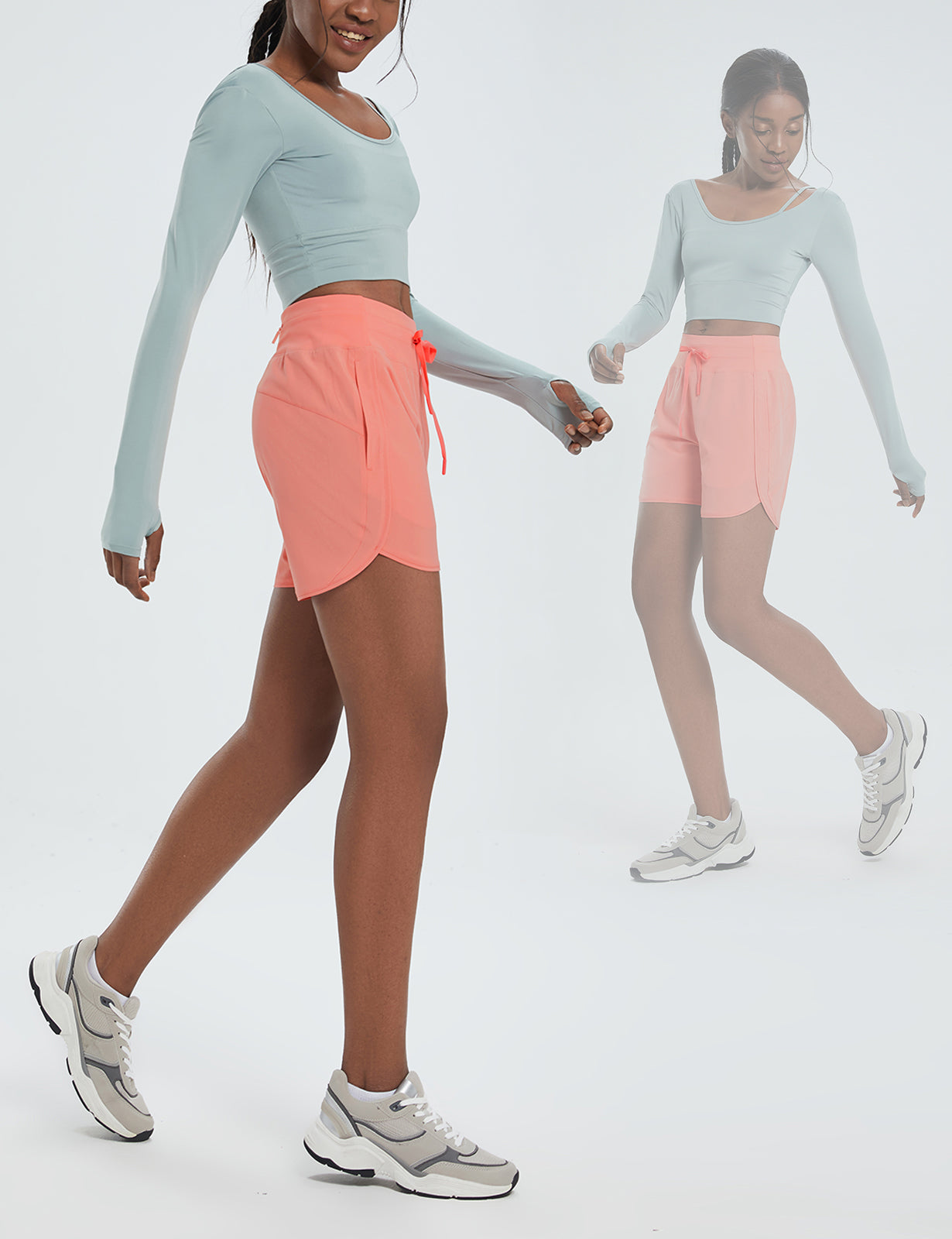Model wearing coral high-waisted 5" inseam quick-dry running shorts with side slits. #color_Pink