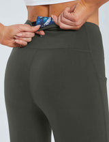 Laureate women's dark grey yoga capris, woman tucking card into back pocket.