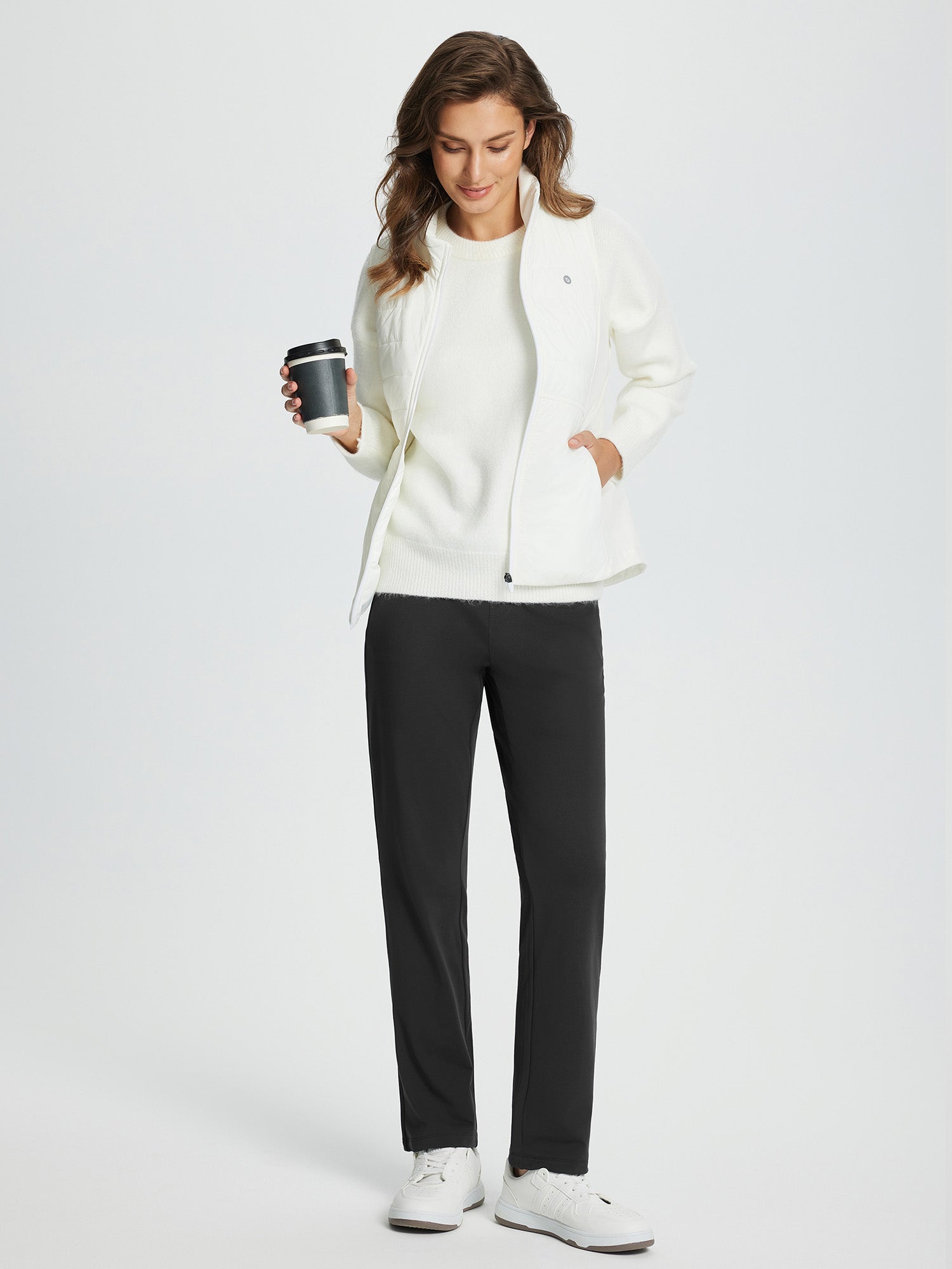 Black fleece-lined straight-leg golf pants on woman with white top and jacket, holding coffee. #color_Black
