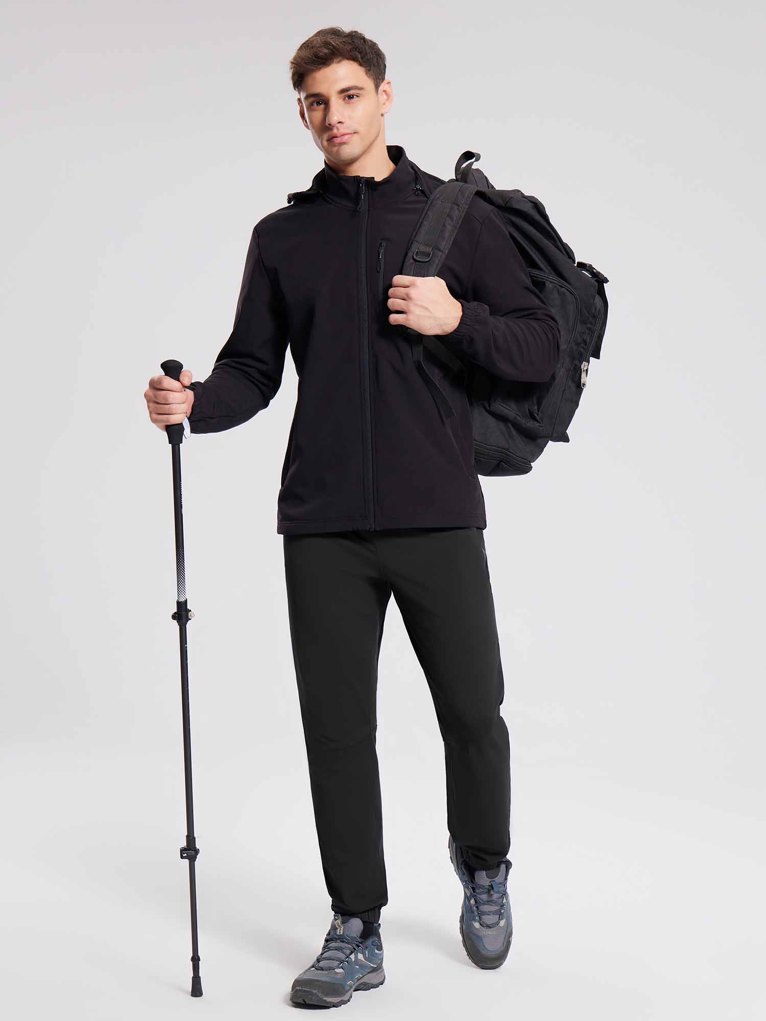 Men's black reflective fleece joggers for hiking, with backpack and pole. #color_Black