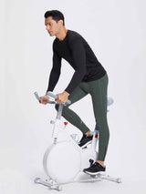 Men's dark green fleece lined running tights with ankle zippers demonstrated on a man cycling. #color_Dark Gray