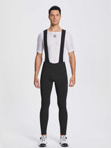 Black men's fleece bib cycling tights featuring padded design, worn on a model. #color_Black