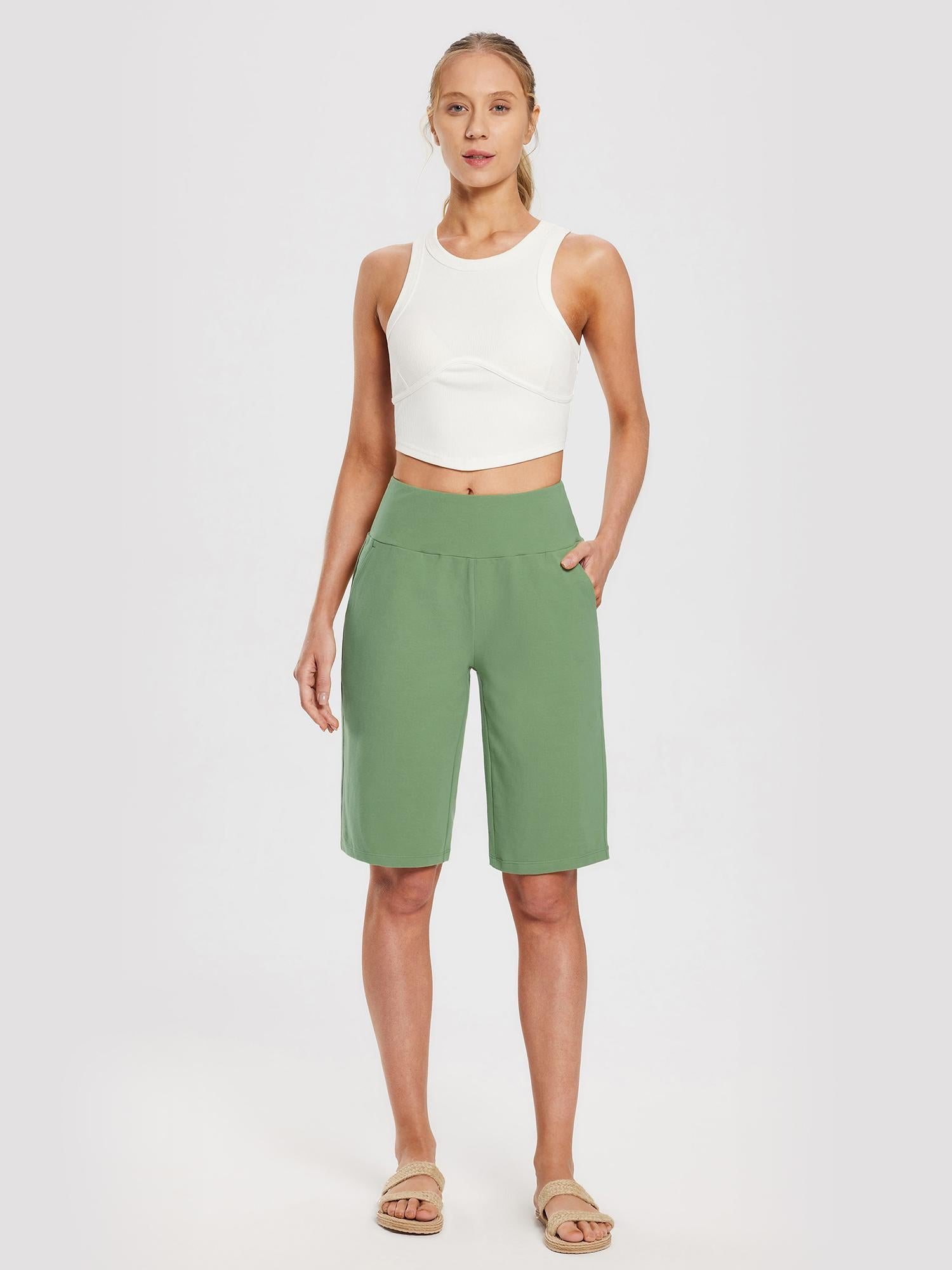 Women's light green 12" cotton Bermuda shorts, wide elastic waist, pockets. Styled with white crop top. #color_Green