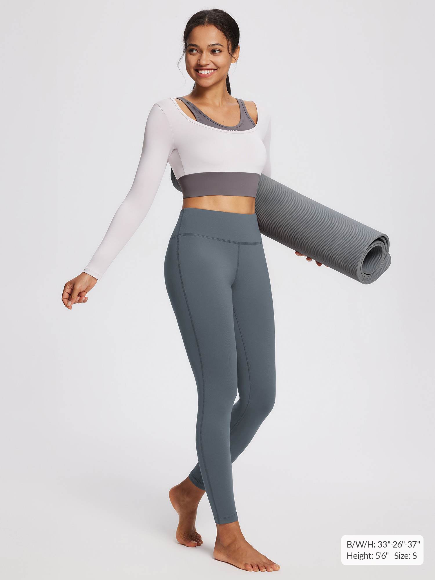 Women's petite grey fleece-lined yoga leggings with high waistband, model holding mat.