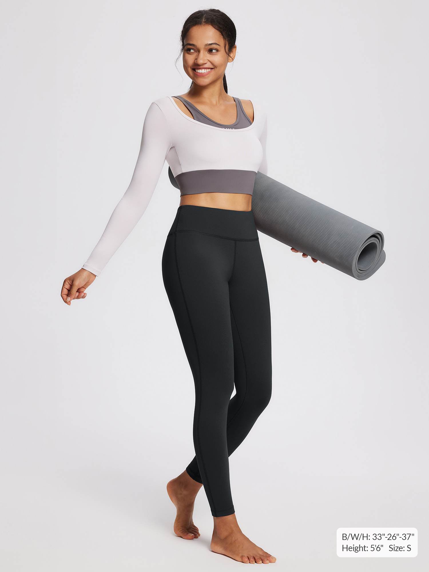 Black fleece-lined yoga leggings with high waistband, worn by a model holding a mat.