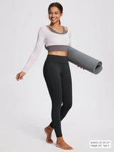 Black fleece-lined yoga leggings with high waistband, worn by a model holding a mat.