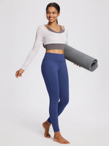 Woman in blue thermal fleece lined yoga leggings & crop top holding mat #color_Black/Blue