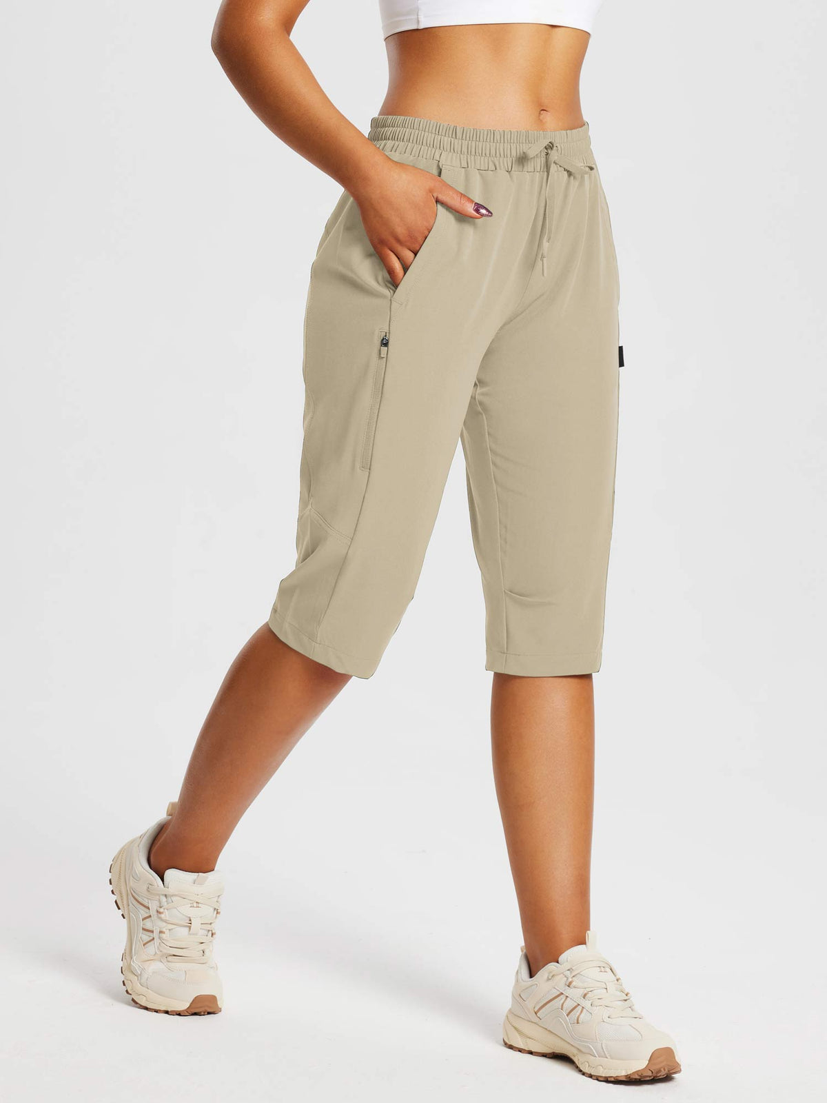Woman wearing beige DWR pocketed capri pants for everyday outdoor comfort and hiking. #color_Doeskin