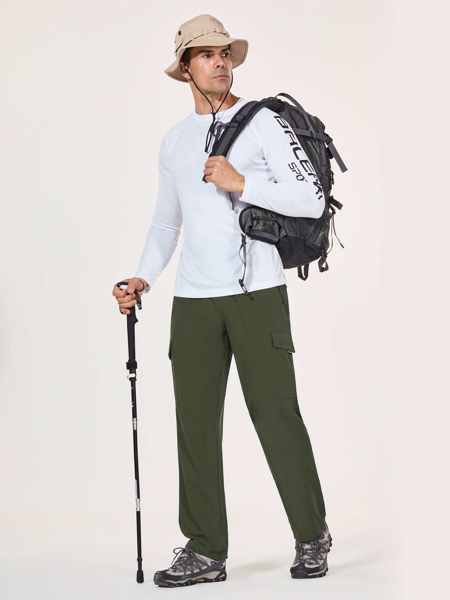 Man in olive green UPF 50+ quick-dry hiking cargo pants with backpack and hiking stick. #color_Army Green