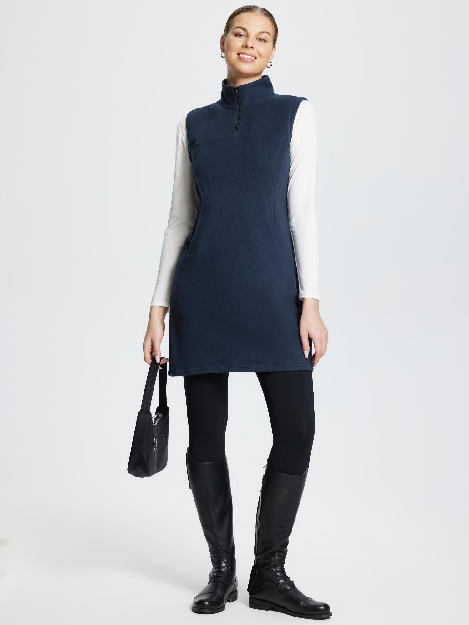 Model wearing navy outdoor sleeveless fleece thermal dress, leggings, and boots.