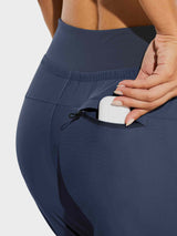Women's navy high-waisted hiking joggers with earbuds in zippered pocket. #color_Navy Blue