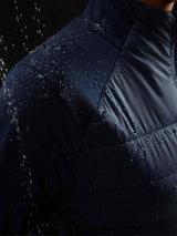 Women's navy quilted jacket with water droplets showing water-resistant fabric.