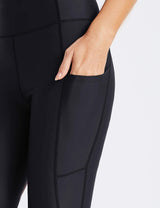 Close-up of black Flyleaf UPF50+ swim shorts showing a side pocket with a hand reaching into it.