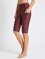 Baleaf Flyleaf UPF50+ maroon high-rise swim shorts with pockets on a woman's legs.