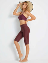 Woman in burgundy UPF50+ high-rise swim shorts and sports bra