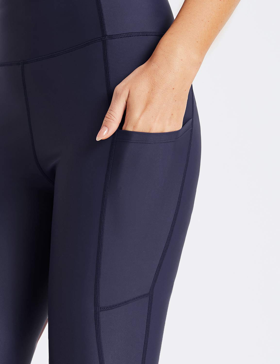 Navy blue Flyleaf UPF50+ high-rise swim shorts with side pockets and a hand reaching into one pocket.