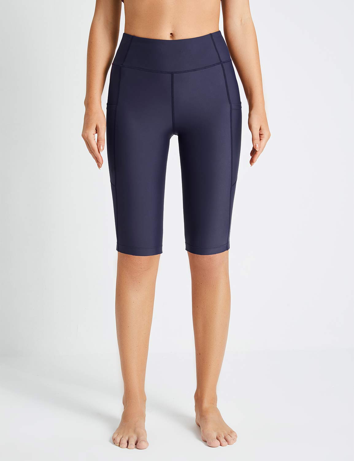 Navy blue Flyleaf UPF50+ high-rise swim shorts with pockets on a woman.