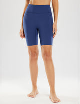 Woman wearing navy blue 8" light compression yoga shorts with high waist and side pockets.