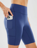 Blue women's 8" yoga shorts with side pockets holding a phone.