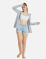 Light gray UPF 50+ hooded zip-up jacket worn by a woman with ripped denim shorts.