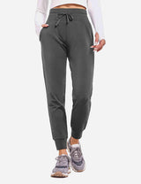 Dark gray Laureate Thermal Tapered Joggers with drawstring and pockets. Worn with white top and sneakers.