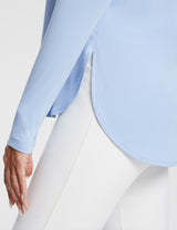 Light blue UPF 50+ long sleeve shirt with side slits at the hem and thumb loops, worn with white pants. #color_Kentucky Blue