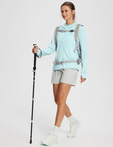 Light blue UPF 50+ hooded zip-up jacket on woman with grey shorts, backpack, and hiking pole.